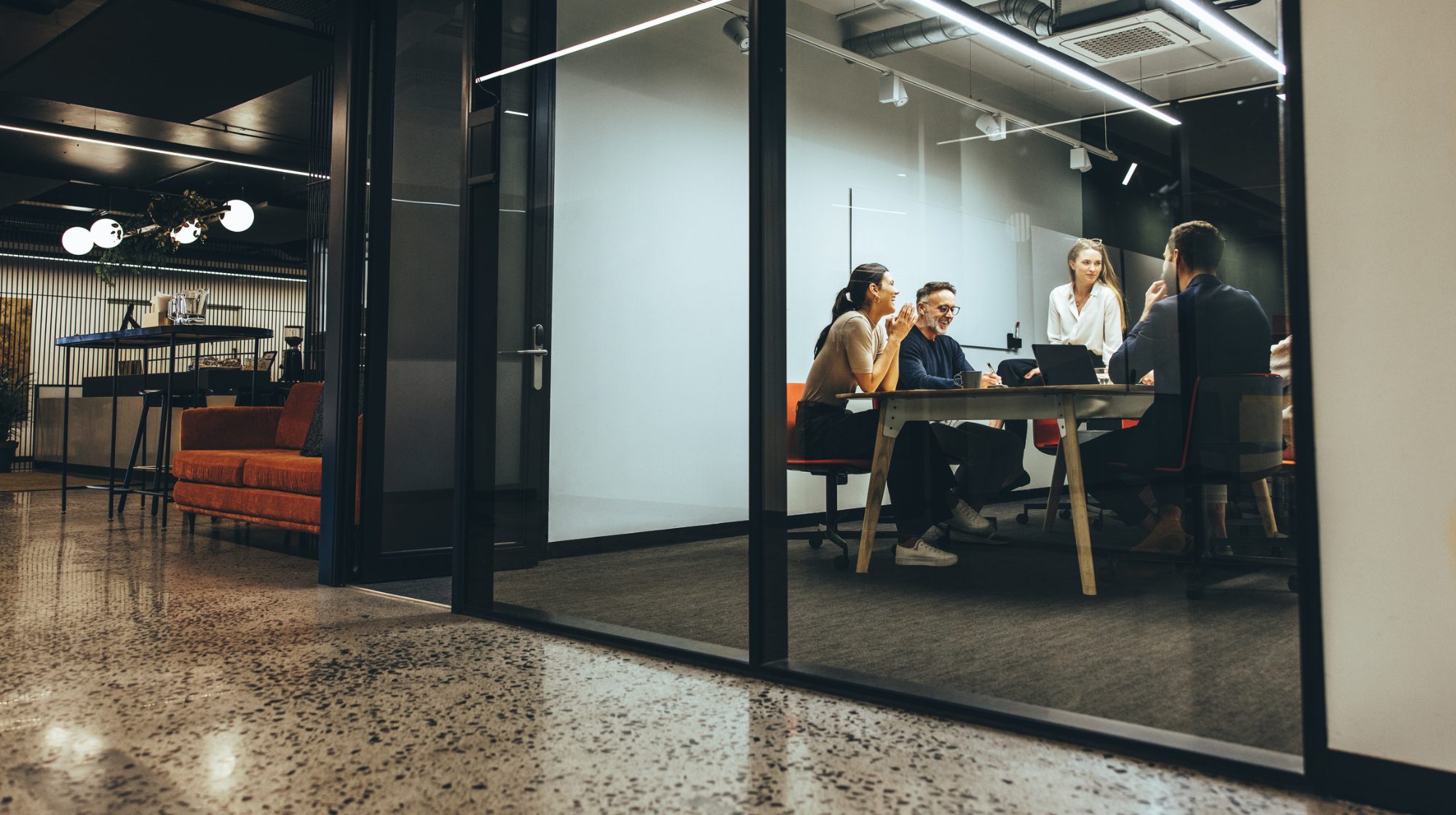 A leadership team meeting in a glass-walled conference room